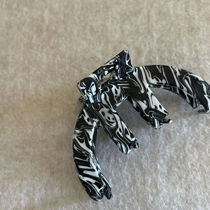 Close-up of marble pattern acetate hair claw clip with black and white ink flow design