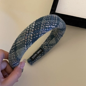 Detail of blue plaid sponge headband with woven texture and Hand Made interior label