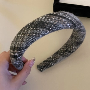 Detail showing grey tweed padded headband with soft knit texture and logo label