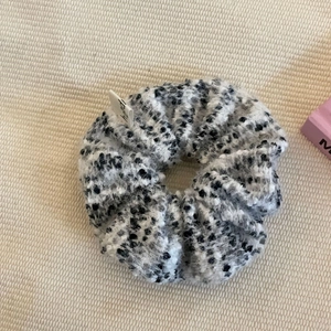 Elegant black and white tweed scrunchie hair tie with a small branded fabric label