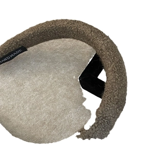 Brown faux lamb wool sponge headband for women with a handmade label and plush texture