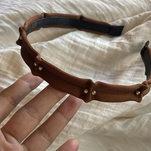 Détail du serre-tête en tissu plissé marron avec perles argentées et doublure antidérapante