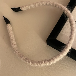 Close-up of knit fabric texture and elegant pleated pattern on the beige headband
