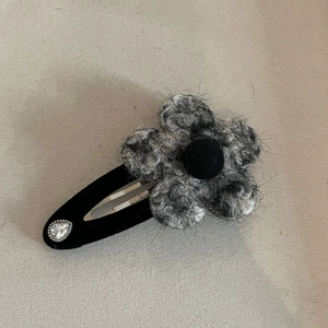 Detail of grey plush flower hair clip with velvet base and sparkling teardrop rhinestone