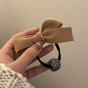 Brown velvet bow hair tie with a sparkling rhinestone ball charm for elegant hairstyling