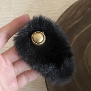 Elegant plush BB hair clip in black faux fur with a vintage gold button detail for women
