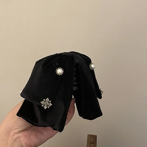 Detail of soft black velvet hair claw clip with elegant pearls and vintage rhinestone accent