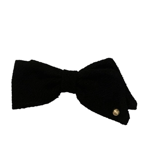 Elegant black tweed bow hair clip with gold button accent on a white background