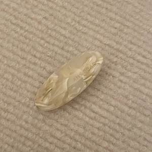 Vintage acetate cream marble oval hair clip with Amy Bear engraving on knit background