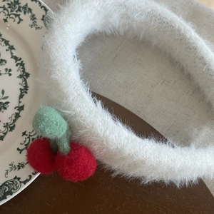 Sweet white plush headband with red cherry decor on retro background for women