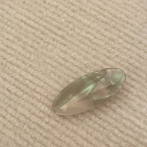 Close-up of green and cream marble acetate hair clip on soft knitted background