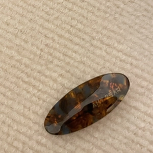 Detail shot of vintage acetate hair clip with tortoise shell pattern and logo