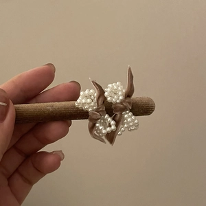 Detail of brown velvet bow hair clips with white imitation pearls in a vintage style