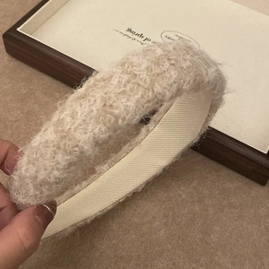 Detail of beige plush headband showing fluffy lamb wool texture and non-slip lining band
