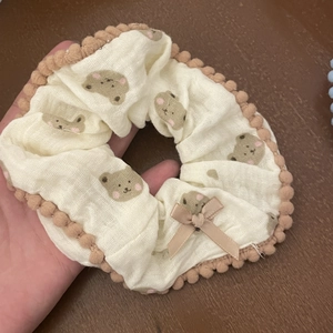 Detailed texture of bear print scrunchie with plush trim and pink satin bow detail