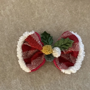 Christmas bow hair clip with glitter stripes, white faux fur edges, and green holly leaves