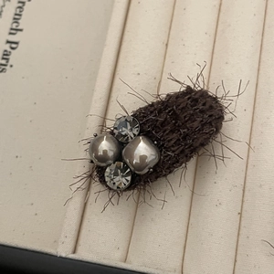 Elegant dark brown plush hair clip with grey pearls and crystals in a jewelry box