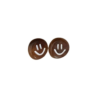 Vintage amber resin stud earrings with minimalist white smiley face design on white base