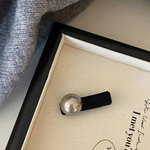 Detailed macro view of the vintage grey pearl and black velvet hairpin in a gift box