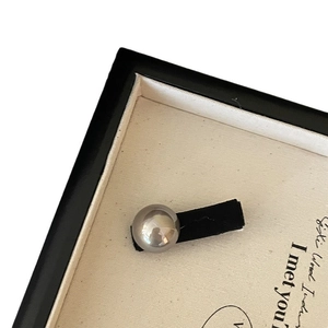 Vintage style hair clip with polished silver bead on black velvet base displayed on a tray