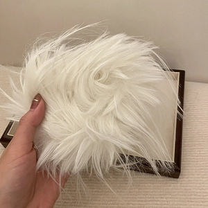 Dettaglio ravvicinato dell'elastico per capelli in piuma bianca con consistenza soffice