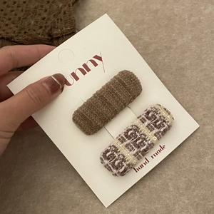 Détails de pinces à cheveux en tricot et tweed marron sur une carte d'affichage