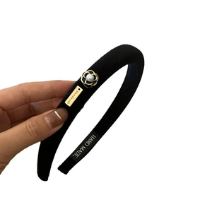 Elegant velvet camellia headband with a gold-edged flower and white pearl decoration