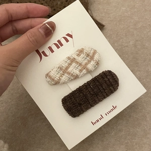 Détail de barrettes faites main à carreaux et en tricot marron aux tons chauds de café au lait