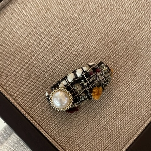 Vintage tweed hair clip with white pearl and gold metal border on khaki fabric
