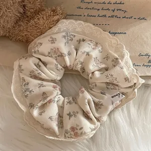 French lace floral scrunchie in cream white with vintage pattern on soft plush background