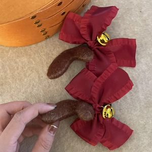 Détail de barrettes en satin rouge avec bois de renne en peluche et grelots dorés