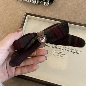 Détail de la pince à cheveux noeud en tweed avec ours brun et cristal coeur rose