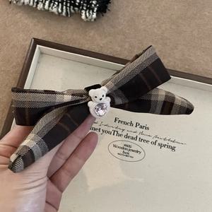 Détail d'une pince à cheveux nœud ours avec tissu à carreaux et gemme cœur rose