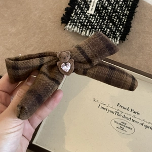 Détail d'une pince à cheveux à nœud écossais marron avec ours floqué et pierre rose