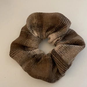 Detailed view of coffee brown plaid scrunchie with soft wool texture for hair styling