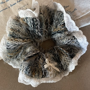Lace knit oversized scrunchie with feather yarn and delicate bow on vintage background