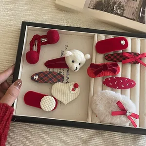 Detailed set of red velvet, plaid, and plush hair clips with a large white bow
