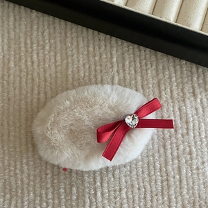 Cute red bow hair clip with plush beige fabric and sparkling heart gemstone