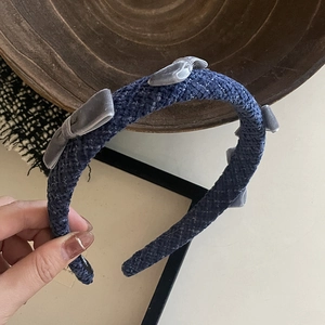 Detail of dark blue woven headband with grey velvet bows in a vintage French style