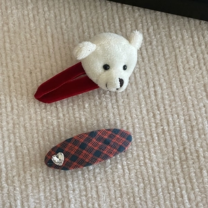 Detail view of red velvet hair clip with plush bear head and heart rhinestone plaid clip