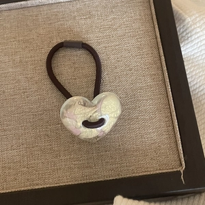 Cute jelly-colored heart hair tie with gold foil in a beige linen display tray