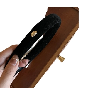 Elegant black corduroy headband with a stylish gold oval metal buckle for women