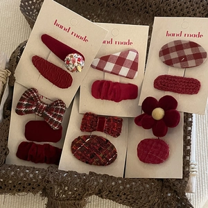 Detailed set of handmade festive red velvet and plaid hair clips for girls in a basket