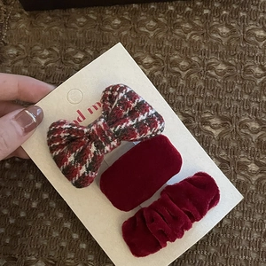 Detail view of festive red velvet hair clips and checkered bow accessory set for girls
