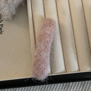 Detailed texture of pink plush lamb wool fabric on a sweet rectangular hair clip