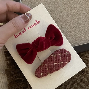 Detail of red velvet and tweed handmade bow hair clips set on a kraft display card