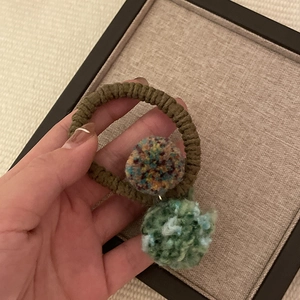 Handmade forest green knitted hair tie with two colorful yarn pom poms for women