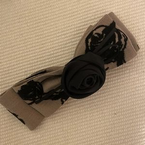 Detail of elegant khaki bow hair claw with black ink-wash roses and floral patterns
