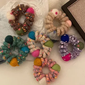 Détail d'élastiques à cheveux spirale en laine colorée avec boules de feutre mignonnes