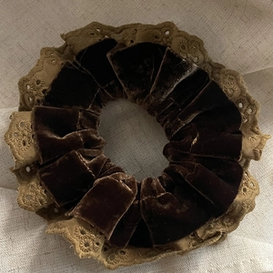 Vintage brown velvet scrunchie with beige lace edges on a cream linen background